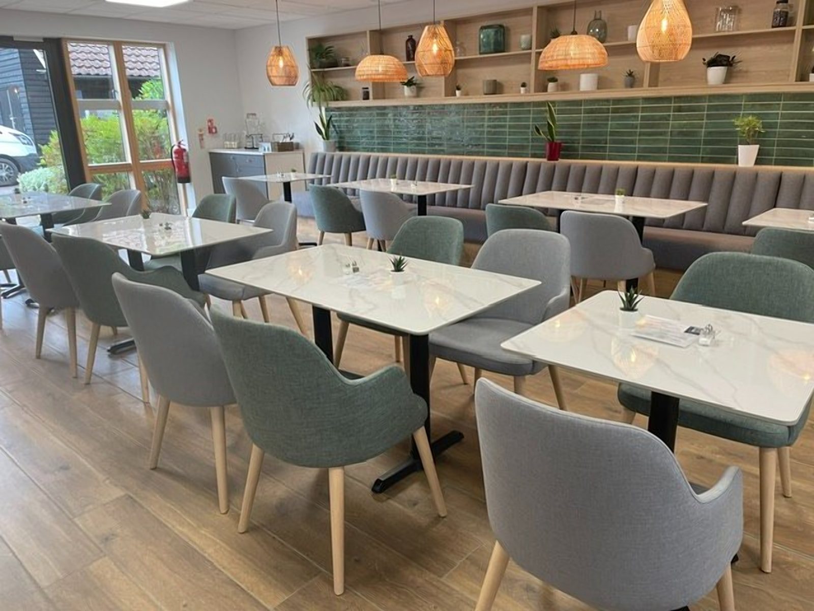 Hospice cafe furniture with grey and sage arm chairs at marble tables