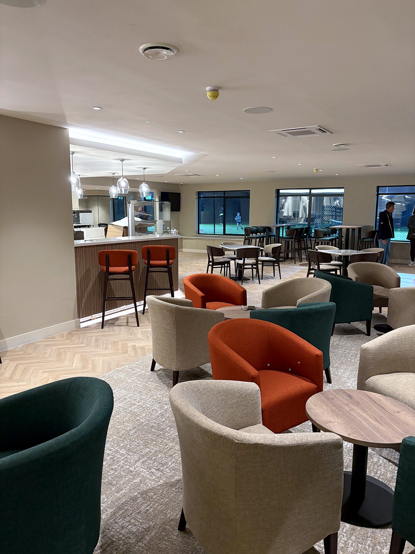 Clubhouse lounge with poseur tables overlooking the floodlit tennis courts
