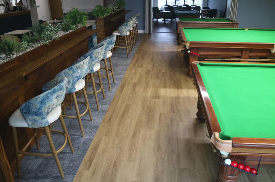 Bar stools at the drinks shelf beside the snooker tables